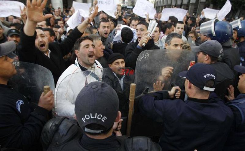 Protesters chant slogans in front of a policeman during a demonstration in Algiers