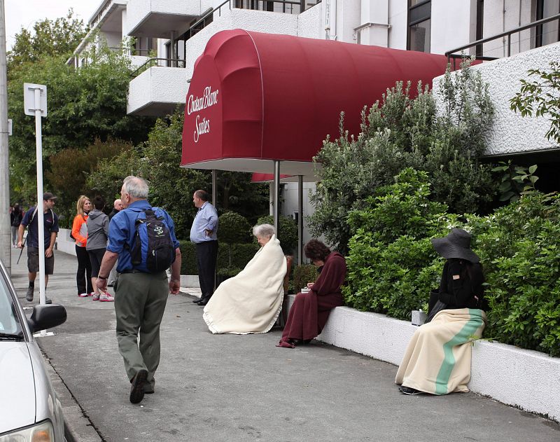 Un grupo de personas permanecen fuera del Hotel Chateau Blanc tras el terremoto