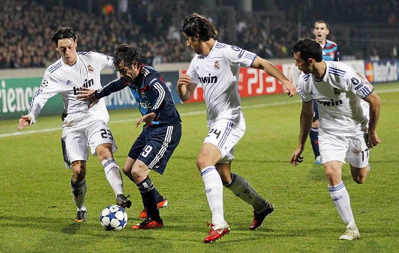 Olympique Lyon's Delgado challenges Ozil of Real Madrid during their Champions League soccer match in Lyon