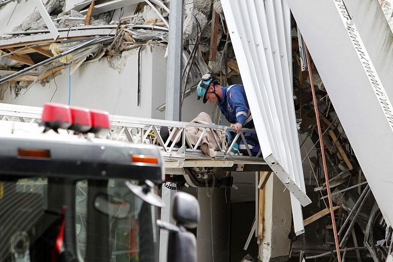 Los bomberos rescatan a una víctima del terremoto de uno de los edificios parcialmente destruidos
