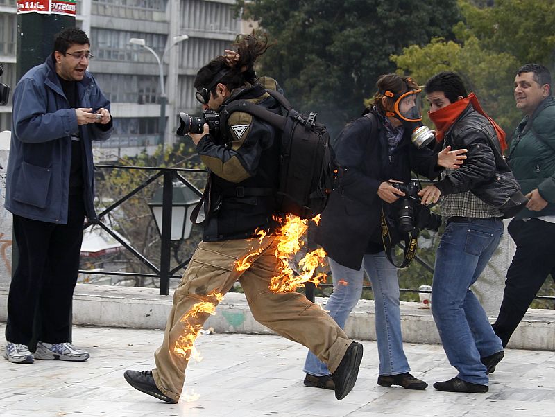 Un fotógrafo se encuentra en llamas mientras intenta escapar  después de que fuera alcanzado por el fuego de una bomba de gasolina  durante las protestas frente al parlamento de Atenas. El reportero no resultó herido.