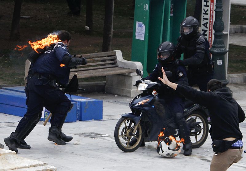 Un agente de policía arde en llamas después de que fuera arrojada una bomba de gasolina, en las protestas que se han producido en Atenas.