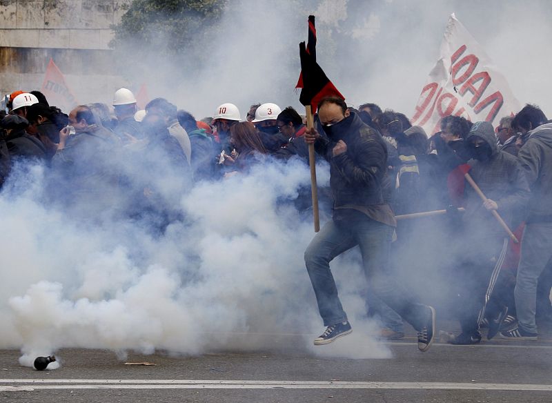 Los manifestantes corren para escapar durante las protestas que se han producido frente al parlamento, en Atenas