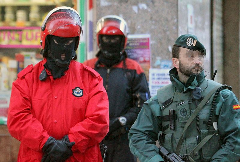 Un guardia civil y dos ertzainas custodian uno de los inmuebles registrados en el marco de la operación en la que han sido arrestados cuatro presuntos miembros de ETA