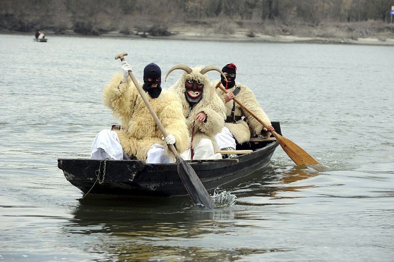 Tres hombres disfrazados con trajes de oveja navegan en un bote por el río Danubio para participar en el desfile de carnaval Busho, en Mohacs, Hungría.