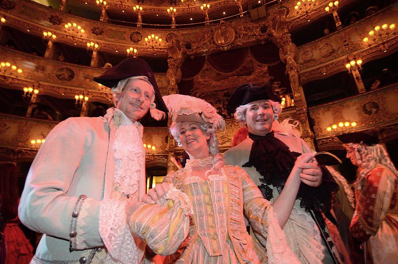 Participantes vestidos con máscaras y ropas típicas del carnaval de Venecia asisten al tradicional Cavalchina Grand Ball que se celebra en el último sábado del evento en el teatro "La Fenice" de Venecia (Italia).