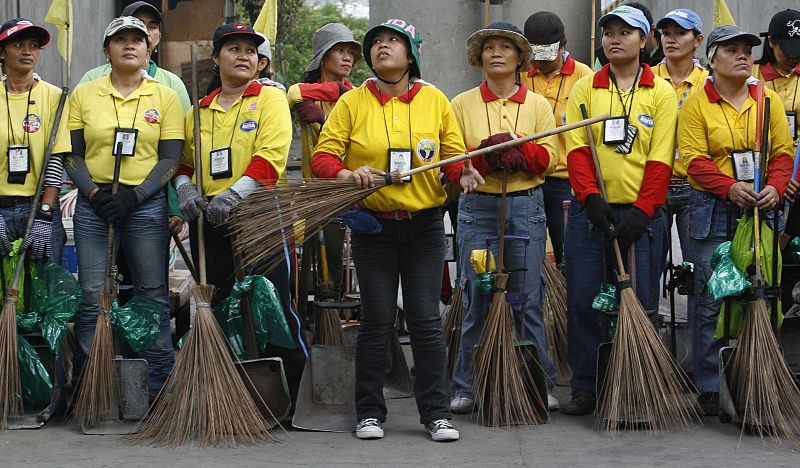 Un grupo de barrenderas espera a la asignación de zonas para trabajar en una calle de Manila (Filipinas).