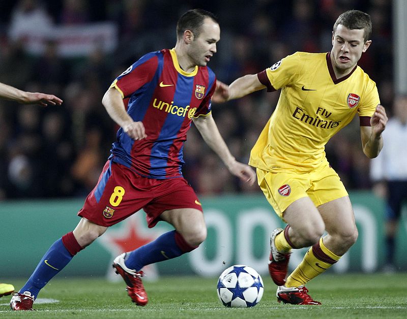 Barcelona's Iniesta fights for the ball with Arsenal's Wilshere during their Champions League soccer match in Barcelona