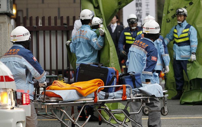 Rescue workers hurry to a building following reports of injuries in Tokyo's financial district after an earthquake off the coast of northern Japan