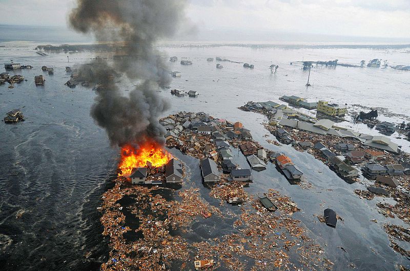 Houses are swept by water following a tsunami and earthquake in Natori City