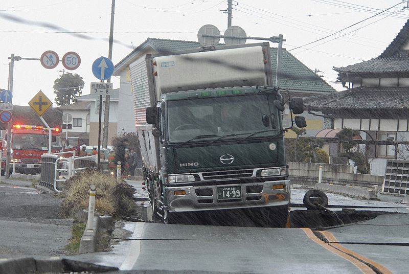 A truck is stuck on a road crack after a powerful earthquake in Iwaki, Fukushima Prefecture