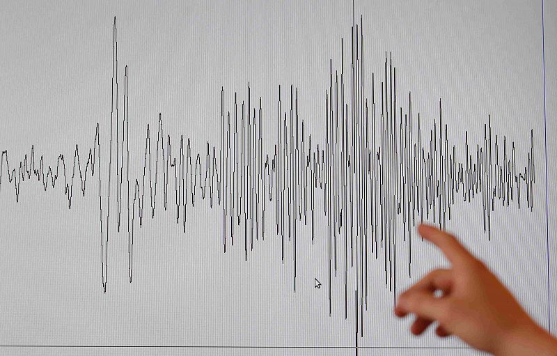 A technician at the French National Seism Survey Institut points at a graph registered today during a major earthquake that hit Japan