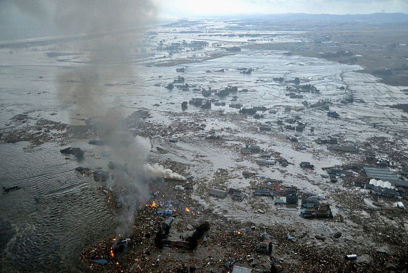 Fires burn in a harbour following an earthquake and tsunami in Natori City, Miyagi Prefecture