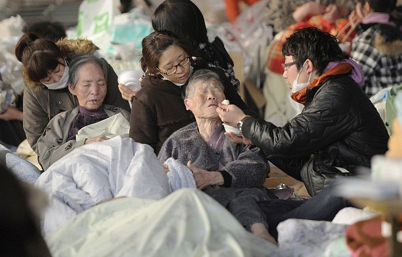 An elderly person has a meal at an evacuation centre in Kesennuma City, Miyagi Prefecture