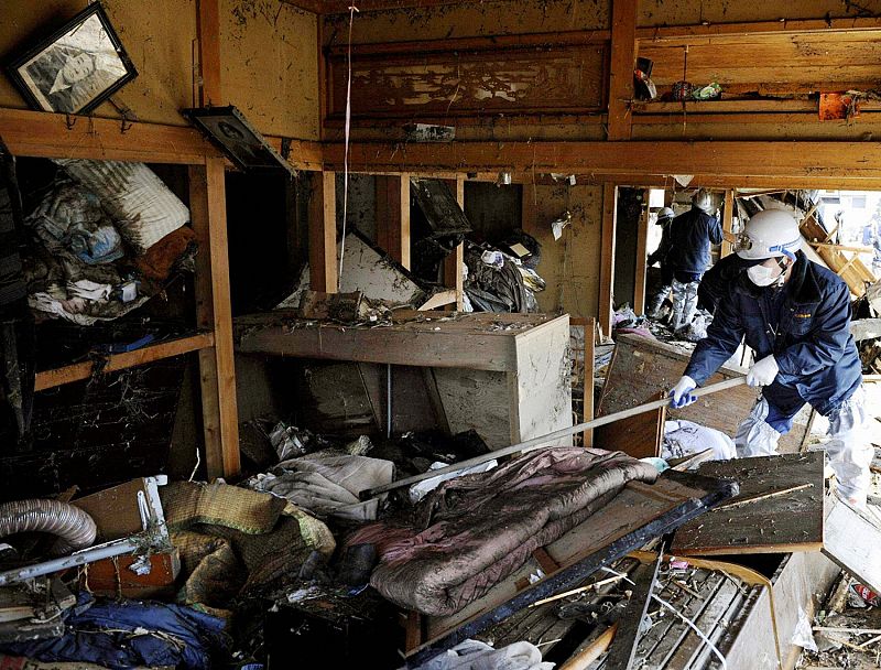 A rescue worker searches for survivors in a damaged house in Sendai in northern Japan
