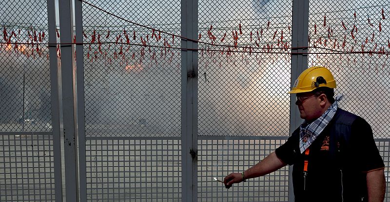 Uno de los pirotécnicos de Pirotecnia Valenciana de Llanera de Ranes (Valencia), sigue, mecha en mano, la secuencia final de la mascletá.