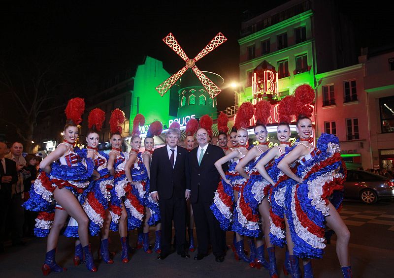 El embajador de Irlanda en Francia, Paul Kavanagh (derecha), y el propietario del Moulin, Rouge Jean-Jacques Clerico, posan junto a bailarinas francesas de cancan frente al cabaret