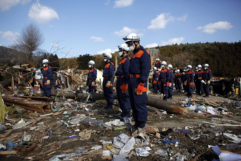 Los miembros de un equipo de rescate en Rikuzentakata, en la prefectura de Iwate, observan el minuto de silencio por las víctimas
