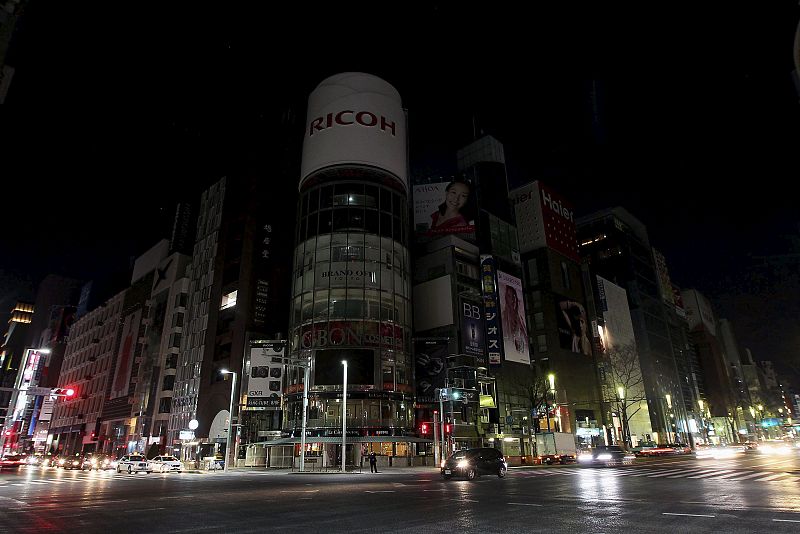 Solo las luces de las farolas están encendidas en el barrio comercial de Ginza, siempre espectacularmente iluminado, en Tokio. Las principales compañías eléctricas de Japón han empezado a cortar el suministro de forma controlada para evitar apagones