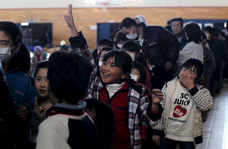 Niños hacen cola para recibir comida en un centro de evacuación en Kesennuma, en la prefectura de Miyagi.