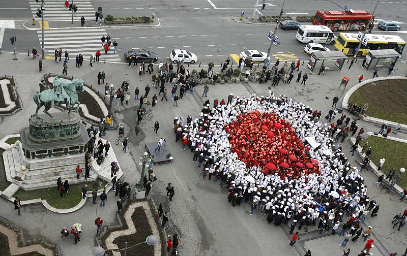 People dressed in red and white clothes make up a flag of Japan during a ceremony for the victims and survivors of the earthquake and tsunami in Japan, at Belgrade's Republic square