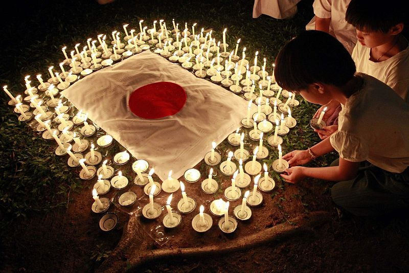 Students light candles as they pray for Japan's earthquake and tsunami victims during a ceremony at the Sathira-Dhammasathan Buddhist meditation centre in Bangkok