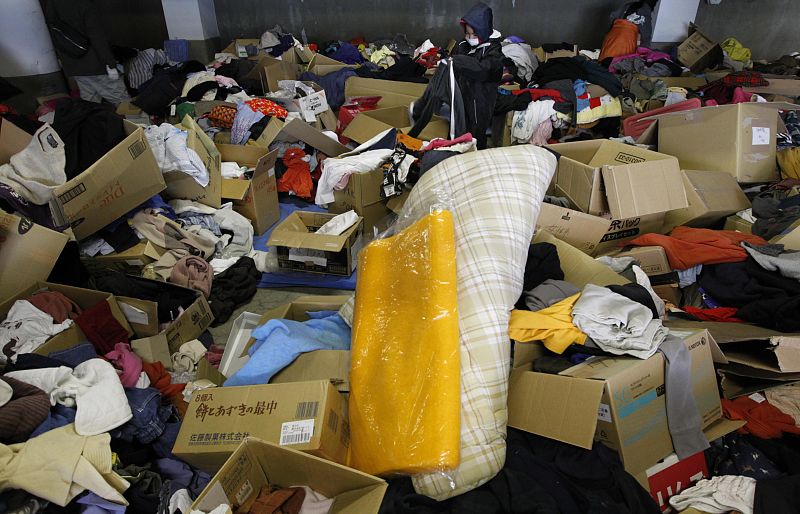 A boy searches for clothes to fit which were donated by people at a Red Cross office in Otsuchi