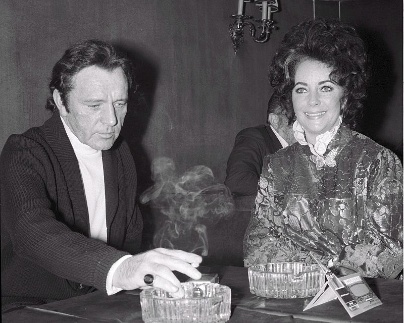 Imagen tomada el 10 de febrero de 1972 que muestra a la actriz estadounidense Elizabeth Taylor junto a su marido el actor británico Richard Burton y el director estadounidense Edward Dmytryk durante una fiesta en el club Moulin Rouge de Budapest, Hun