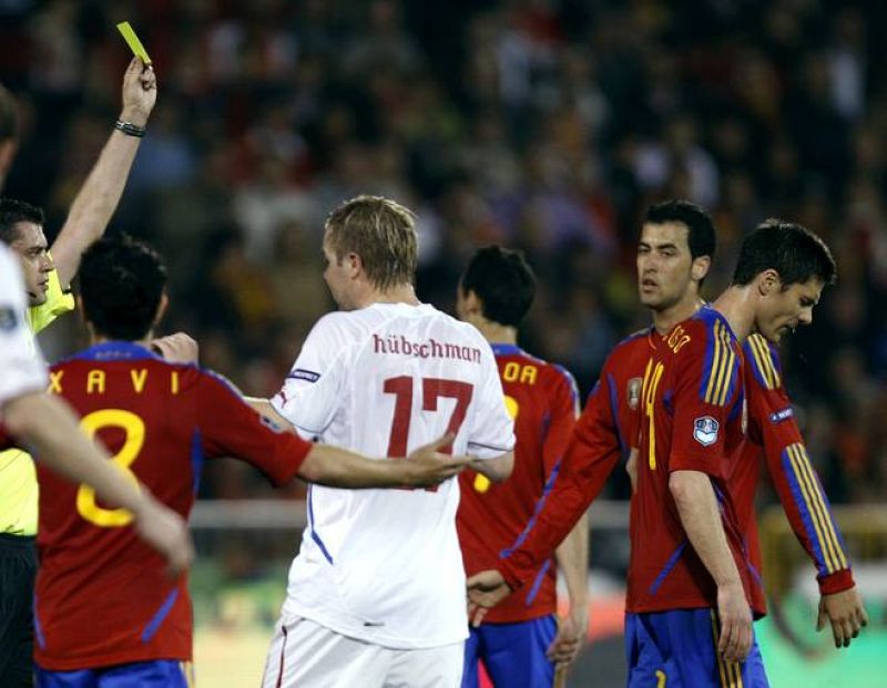 El colegiado hungaro Kassai muestra tarjeta amarilla a Xabi Alonso que sería sustituido en el descanso por el delantero Fernando Torres.