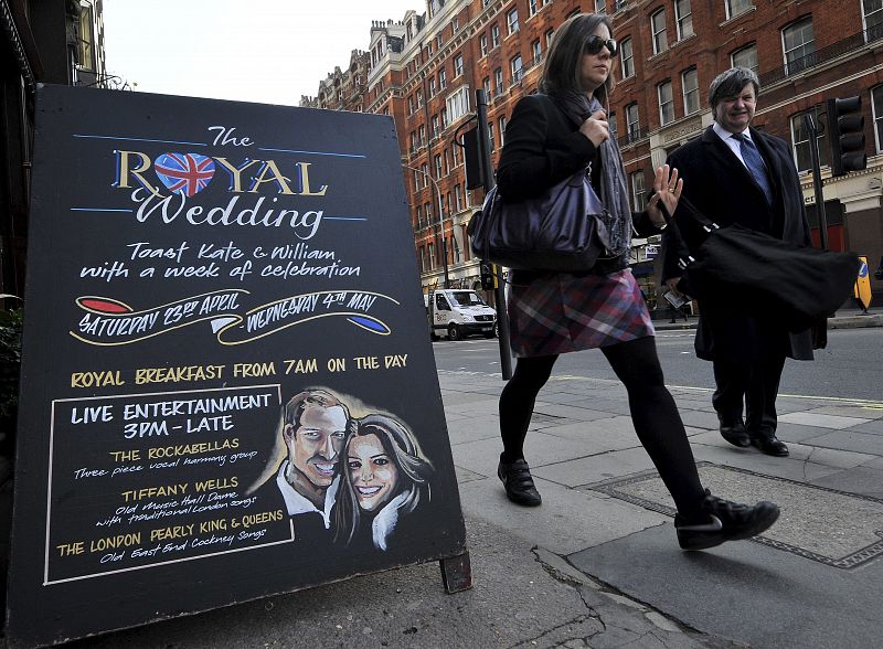 Unos peatones pasan frente a un pub que ofrece un desayuno especial con motivo de la boda