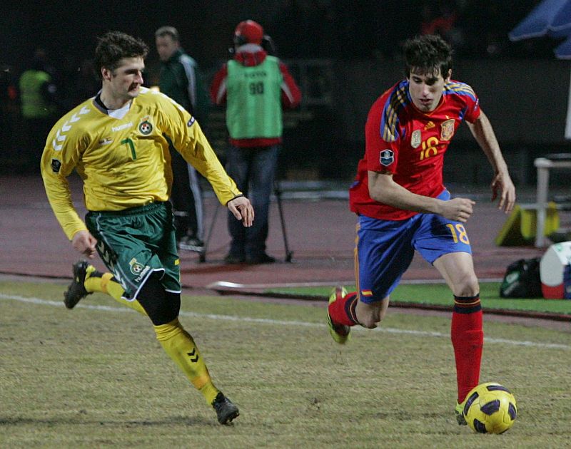El jugador de Lituania Mindaugas Panda hace la marca a Javi Martínez, de España.