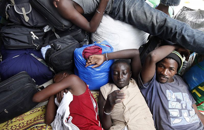 Malians wait for transport to return to their country, near the Mali Embassy, in Abidjan