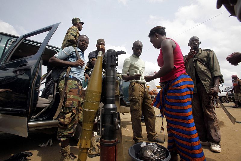 Woman sells water to soldiers loyal to Ivory Coast presidential claimant Alassane Ouattara gathered at the roadside in the main city Abidjan