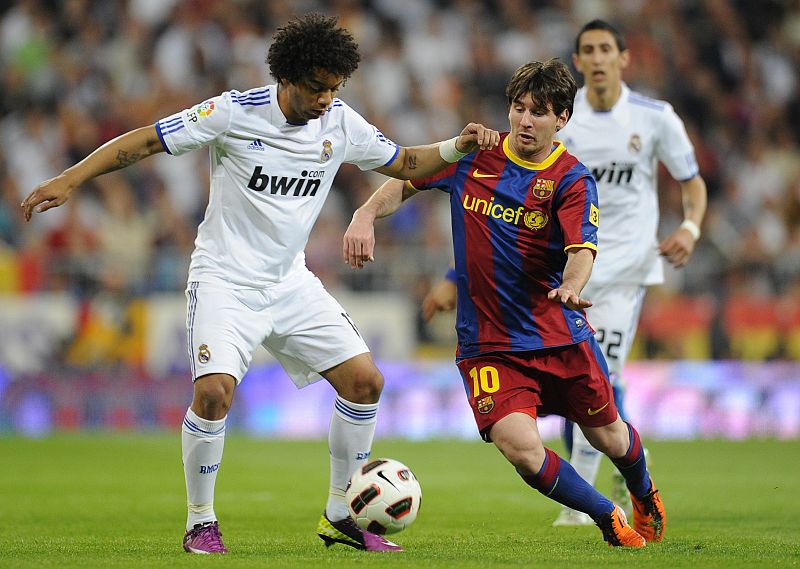 Real Madrid's  Marcelo fights for the ball with Barcelona's Messi during their Spanish first division soccer match in Madrid