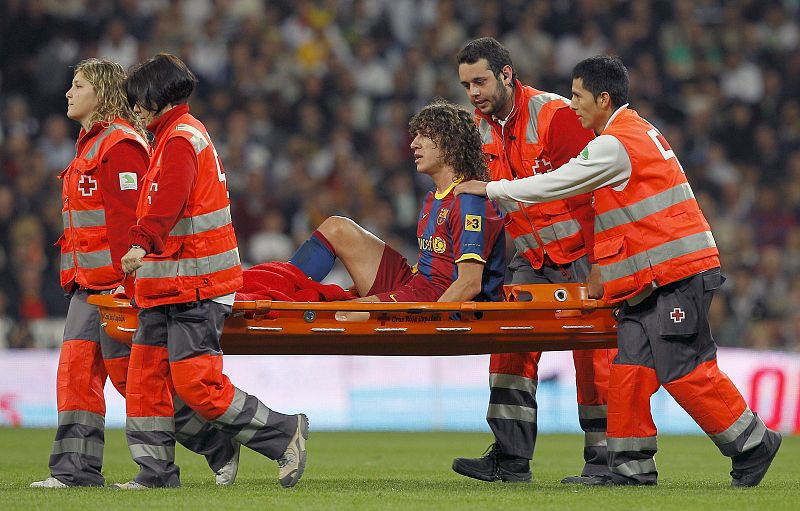 El defensa del FC Barcelona, Carles Puyol, es sacado del campo en camilla.