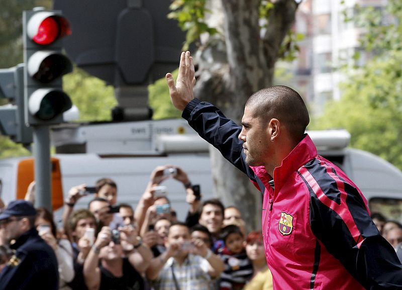 El guardameta Víctor Valdés saluda a los aficionados a la llegada de los jugadores del FC Barcelona al hotel en Valencia.