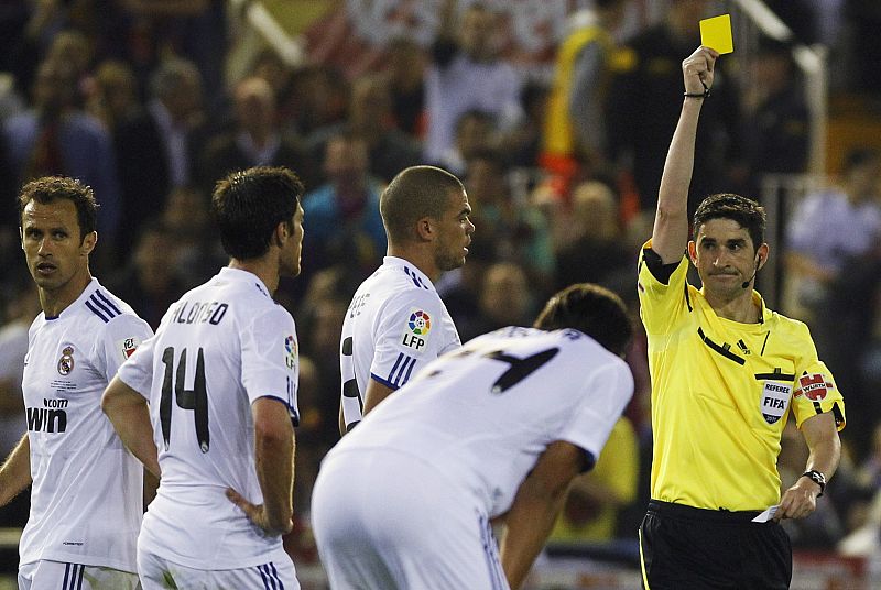 Real Madrid's Xabi Alonso receives a yellow card during their King's Cup final soccer match against Barcelona at Mestalla stadium in Valencia