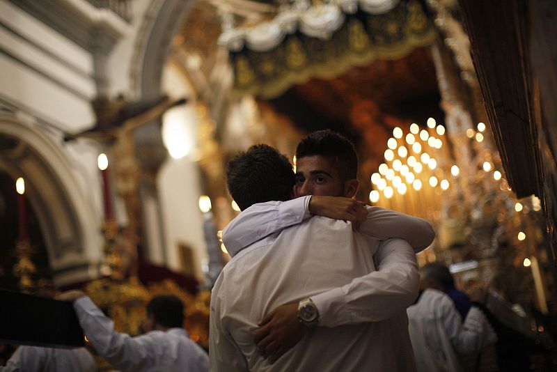 Los miembros de una cofradía de Málaga lloran en el interior de la iglesia después de que la Hermandad haya decidido cancelar la procesión debido a la lluvia