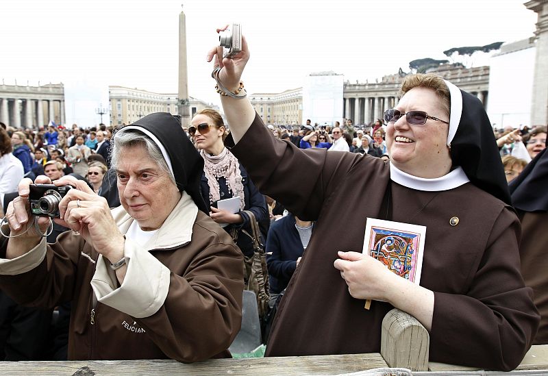 Nuns take pictures before the start of the Easter Mass led by Pope Benedict XVI in Saint Peter's Square at the Vatican