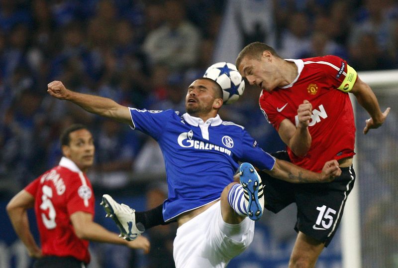 Edu of Schalke 04 heads for the ball with Manchester United's Vidic during their Champions League soccer match in Gelsenkirchen