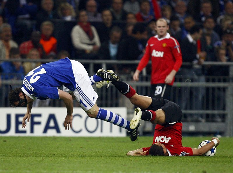 Metzelder of Schalke 04  is tackled by Javier Hernandez of Manchester United during their Champions League semi-final first leg soccer match in Gelsenkirchen