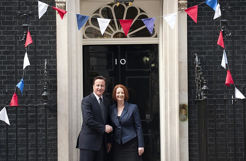 El primer ministro británico, David Cameron, saluda a su homóloga australiana, Julia Gillard