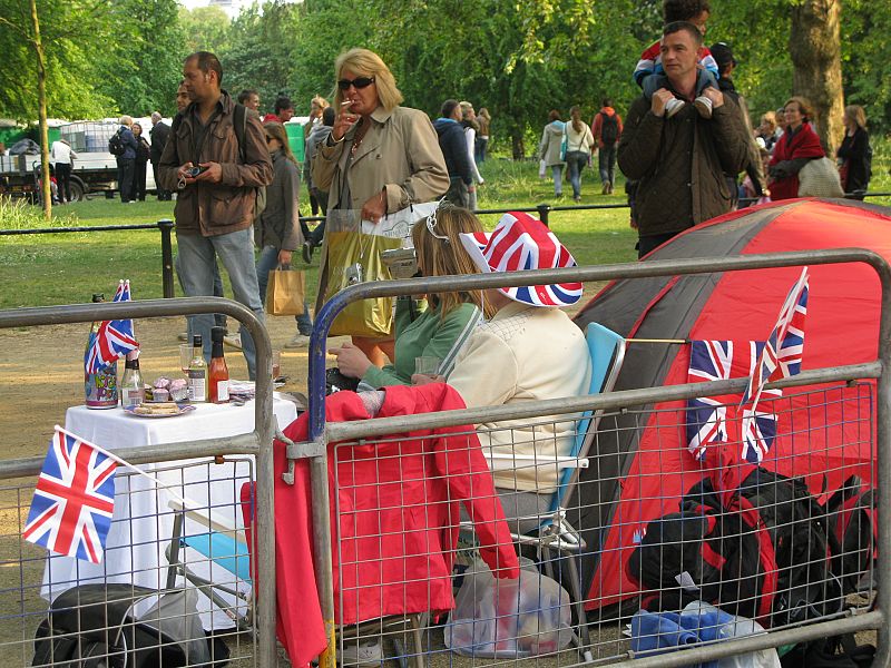 Varias personas pasean junto a los ciudadanos que esperan la llegada del gran día