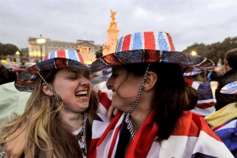 Dos jóvenes bromean frente al Palacio de Buckingham.