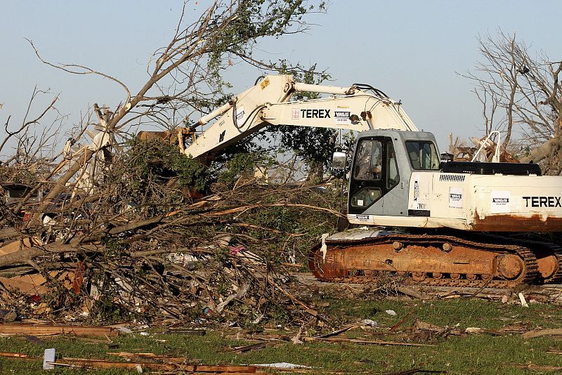 Una excavadora mueve algunos árboles derribados por los tornados en Tuscaloosa