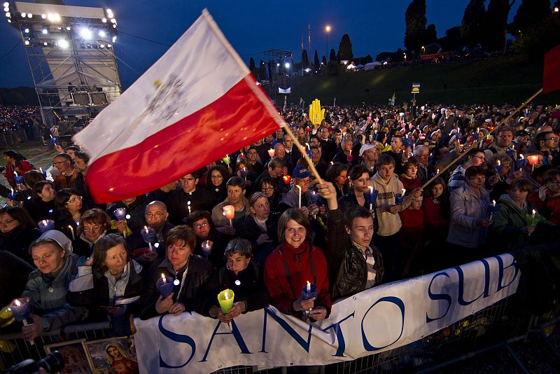 Peregrinos ondean la bandera de Polonia y exhiben un cartel en el que se lee "santo subito" ("santo pronto") en el Circo Máximo de Roma, durante la noche de vigilia de la beatificación mañana del papa Juan Pablo II.