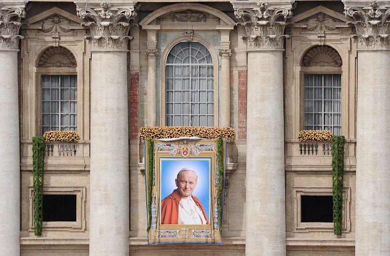 Un cartel del papa Juan Pablo II cuelga de la basílica de San Pedro.