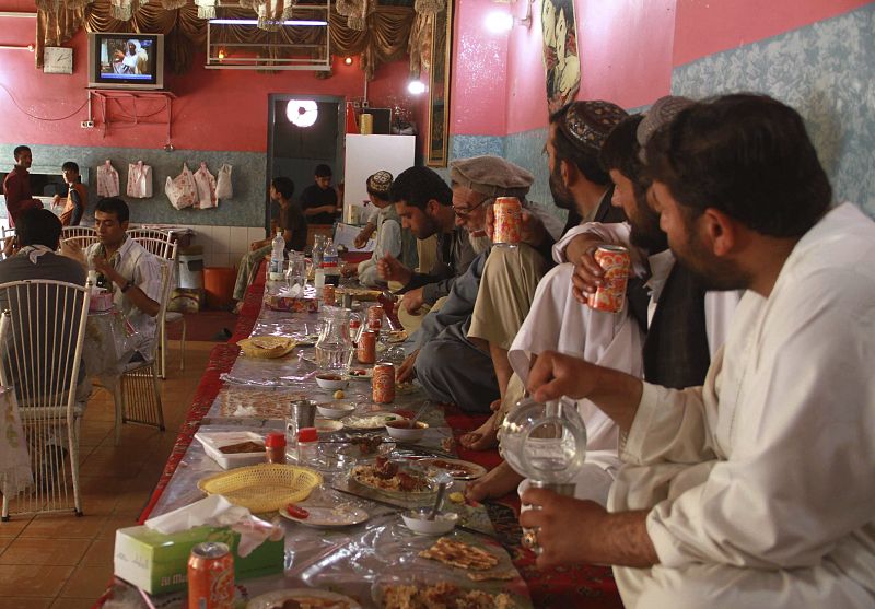 Hombres afganos observan atentos los informativos que se hacen eco de la muerte de Osama Bin Laden en un restaurante en Herat (Afganistán).