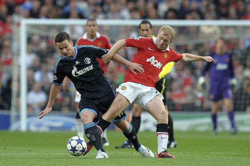 Paul Scholes (d) pelea por el balón con Alexander Baumjohan, del Schalke.