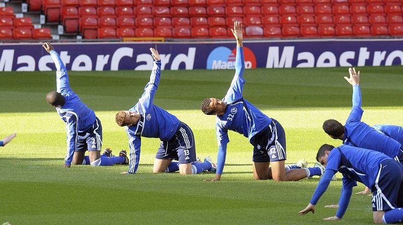 Los jugadores del Schalke 04 estiran durante el entrenamiento previo al partido.